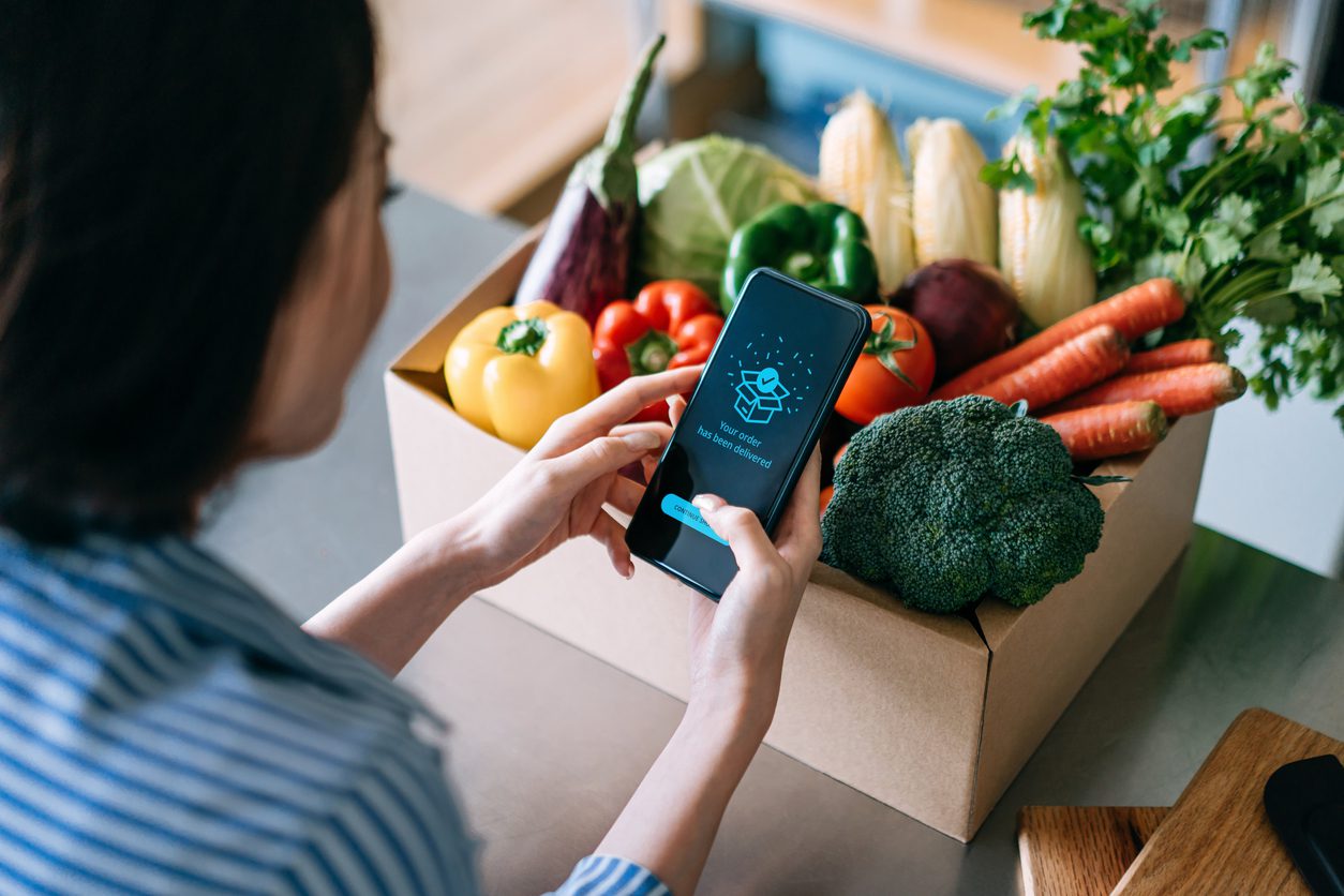 A customer receives a grocery delivery through a subscription from a boutique grocer.